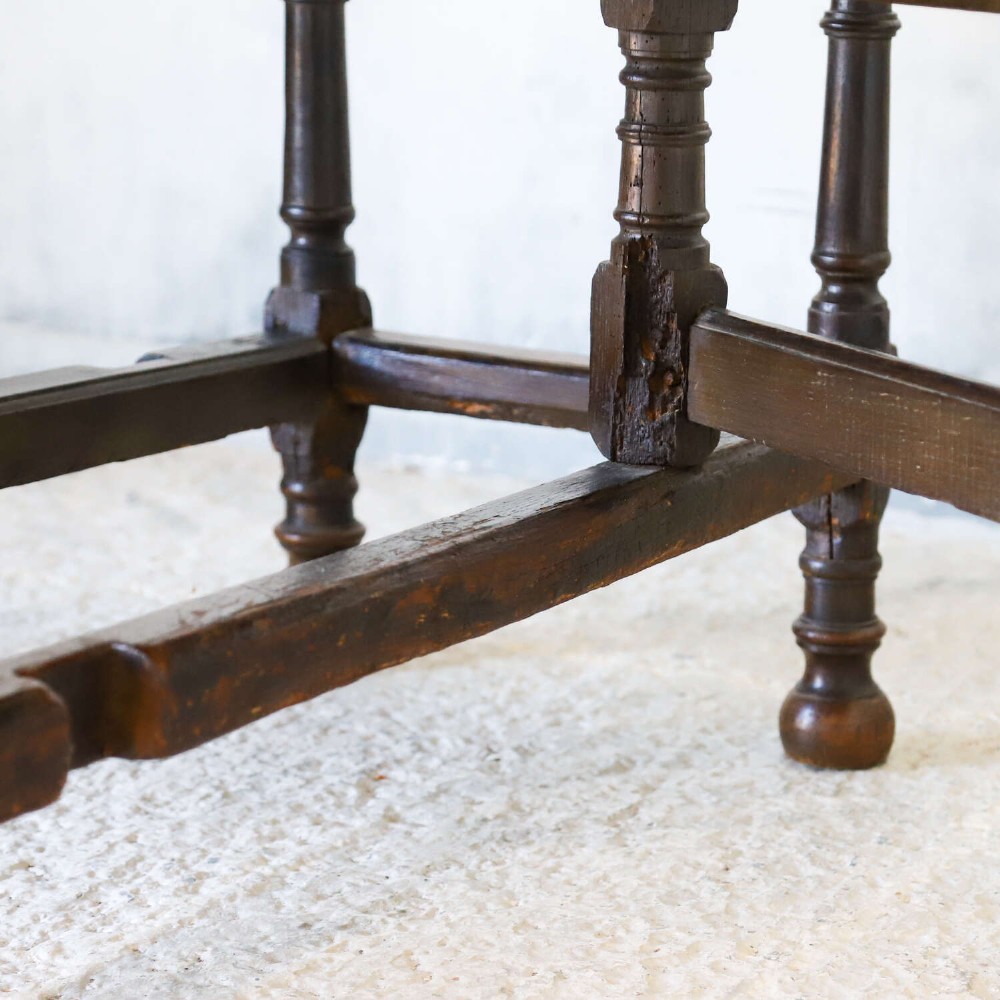 An eighteenth-century oak gateleg drop-leaf table featuring turned legs, lower stretchers, and hinged folding sides. View XI