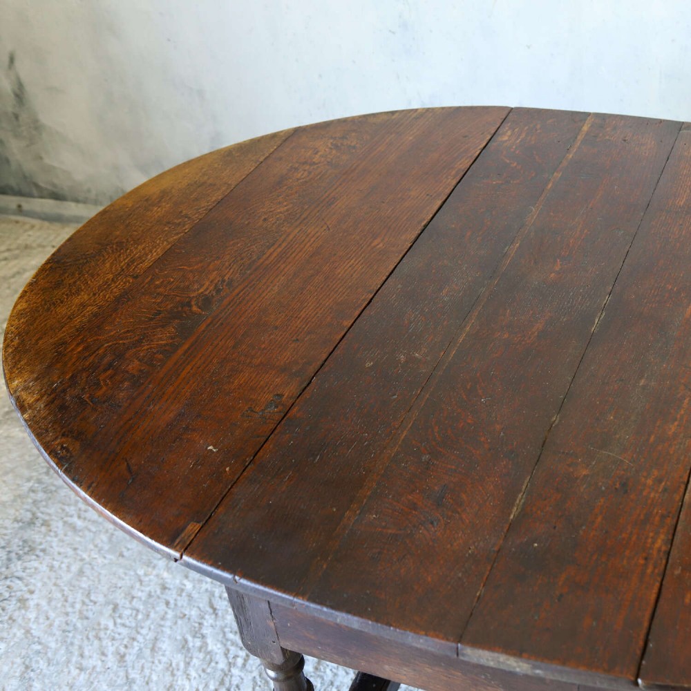 An eighteenth-century oak gateleg drop-leaf table featuring turned legs, lower stretchers, and hinged folding sides. View XIII