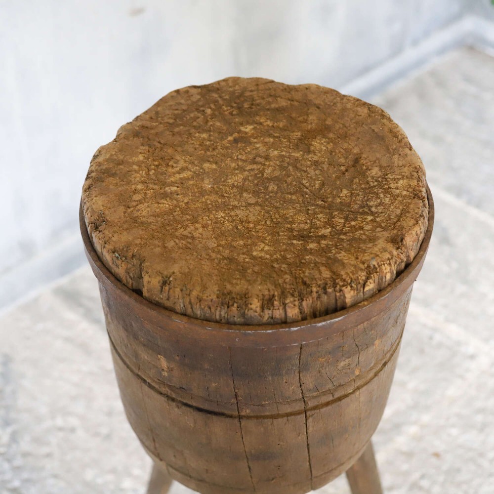 A rustic three-legged French chopping block made from oak and elm with a textured wooden top. View V
