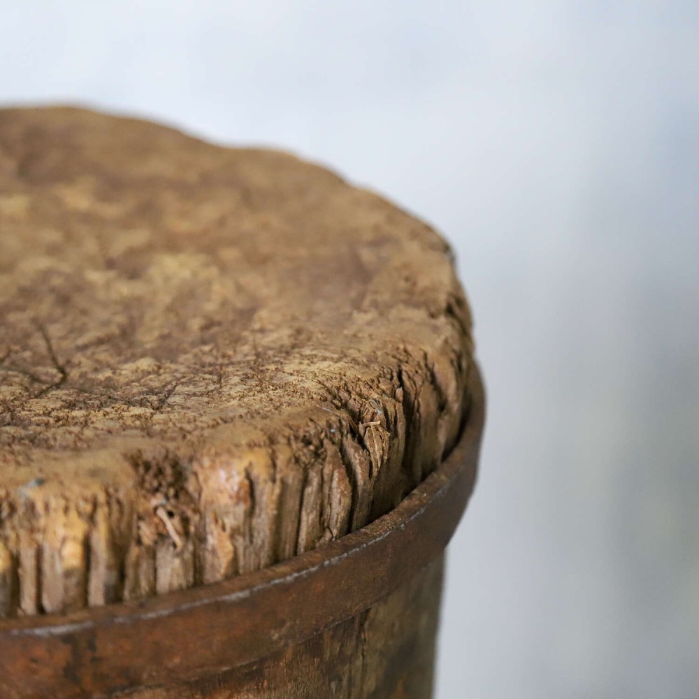 A rustic three-legged French chopping block made from oak and elm with a textured wooden top. View X