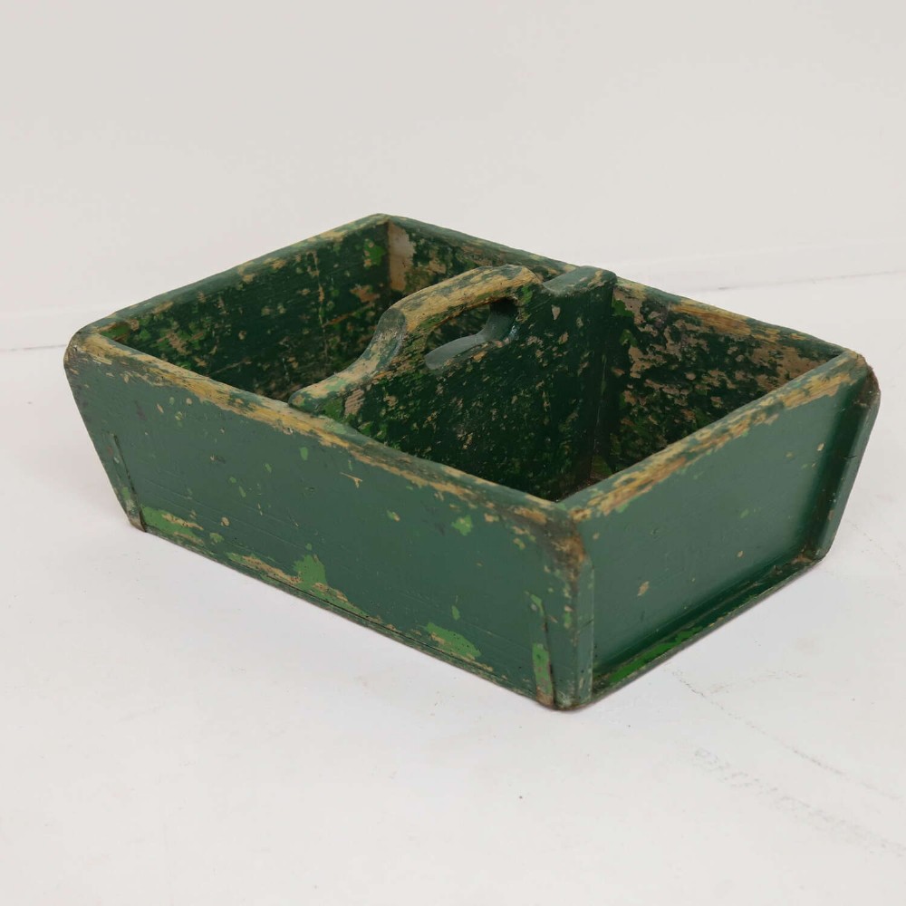 A rectangular dark green painted wooden caddy with a central carrying handle and two compartments, displaying worn paint along the edges. View VII