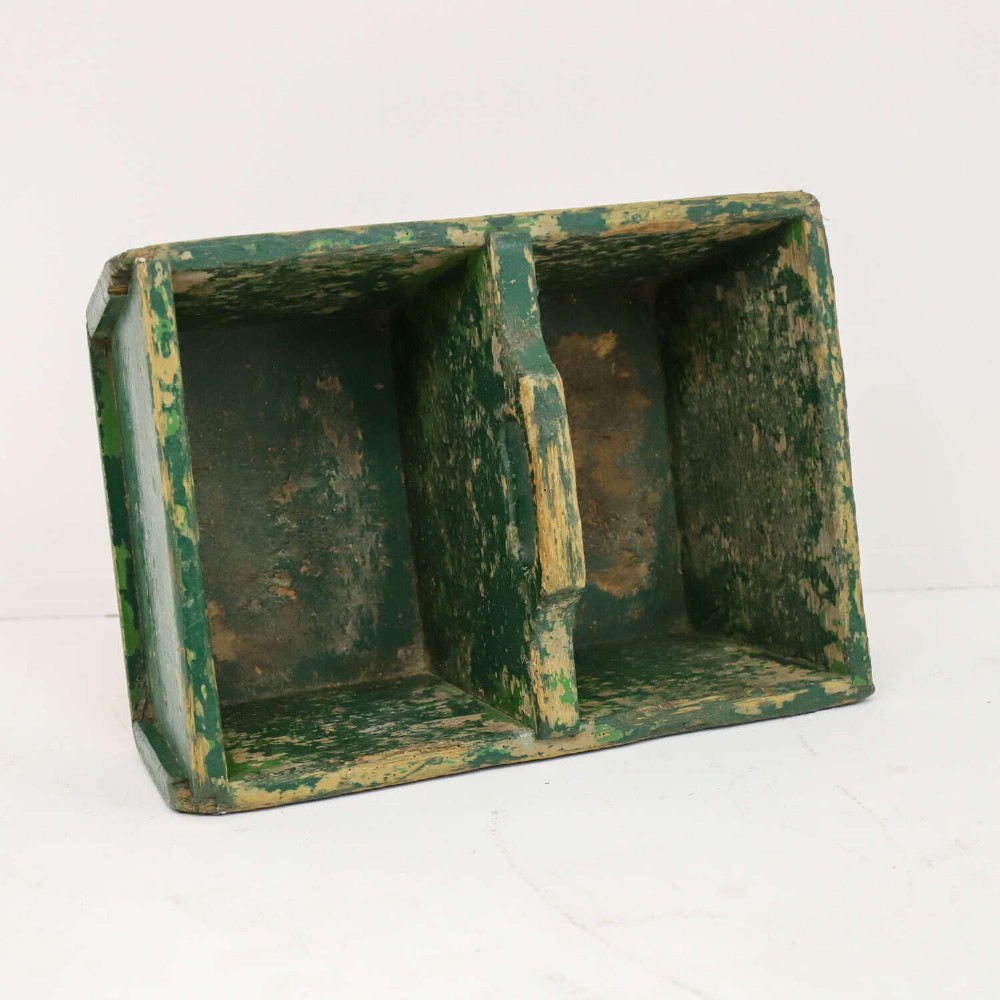 A rectangular dark green painted wooden caddy with a central carrying handle and two compartments, displaying worn paint along the edges. View IX