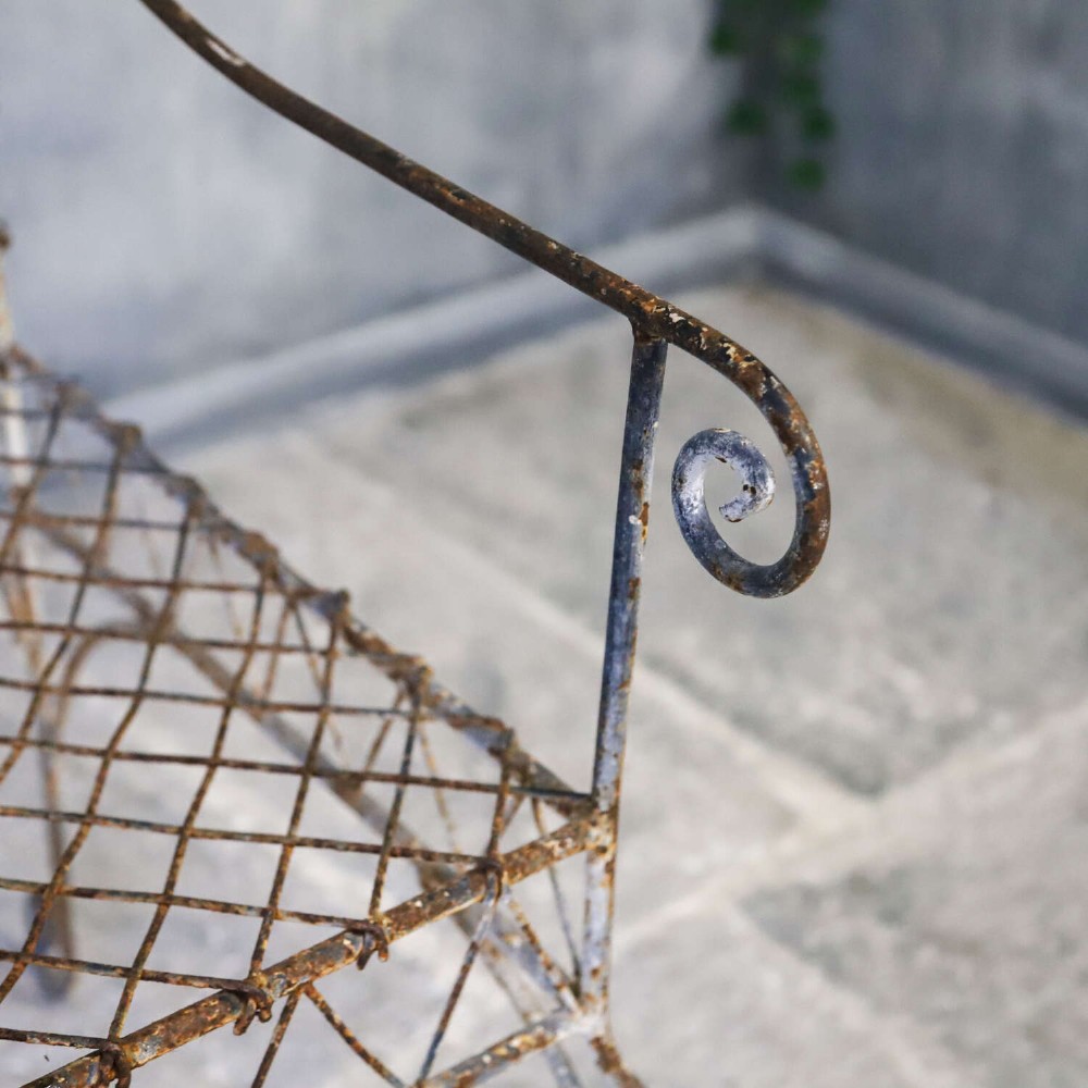 A French Gothic-influenced metal garden bench featuring a triple arched wirework backrest, lattice seat, and scrolled armrests and legs with a weathered, distressed paint finish. View VII