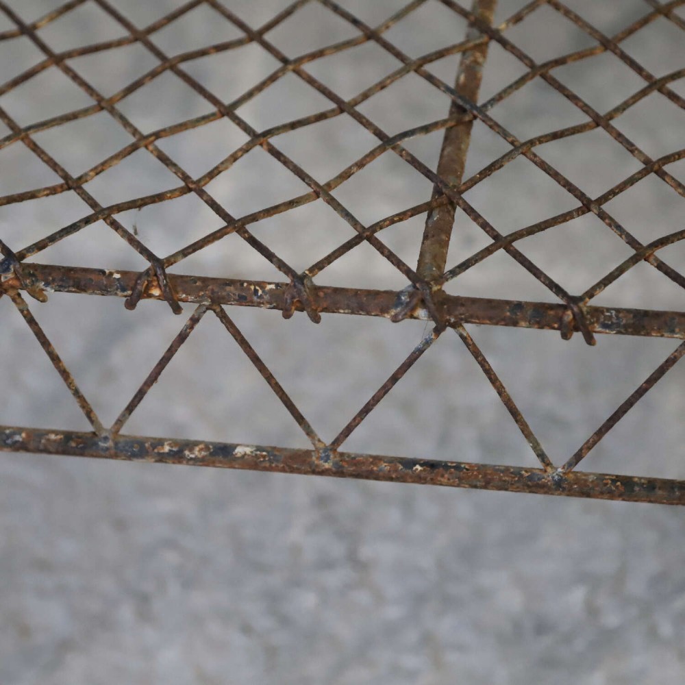 A French Gothic-influenced metal garden bench featuring a triple arched wirework backrest, lattice seat, and scrolled armrests and legs with a weathered, distressed paint finish. View VIII