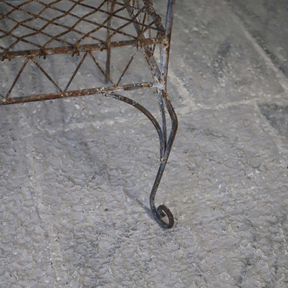 A French Gothic-influenced metal garden bench featuring a triple arched wirework backrest, lattice seat, and scrolled armrests and legs with a weathered, distressed paint finish. View IX