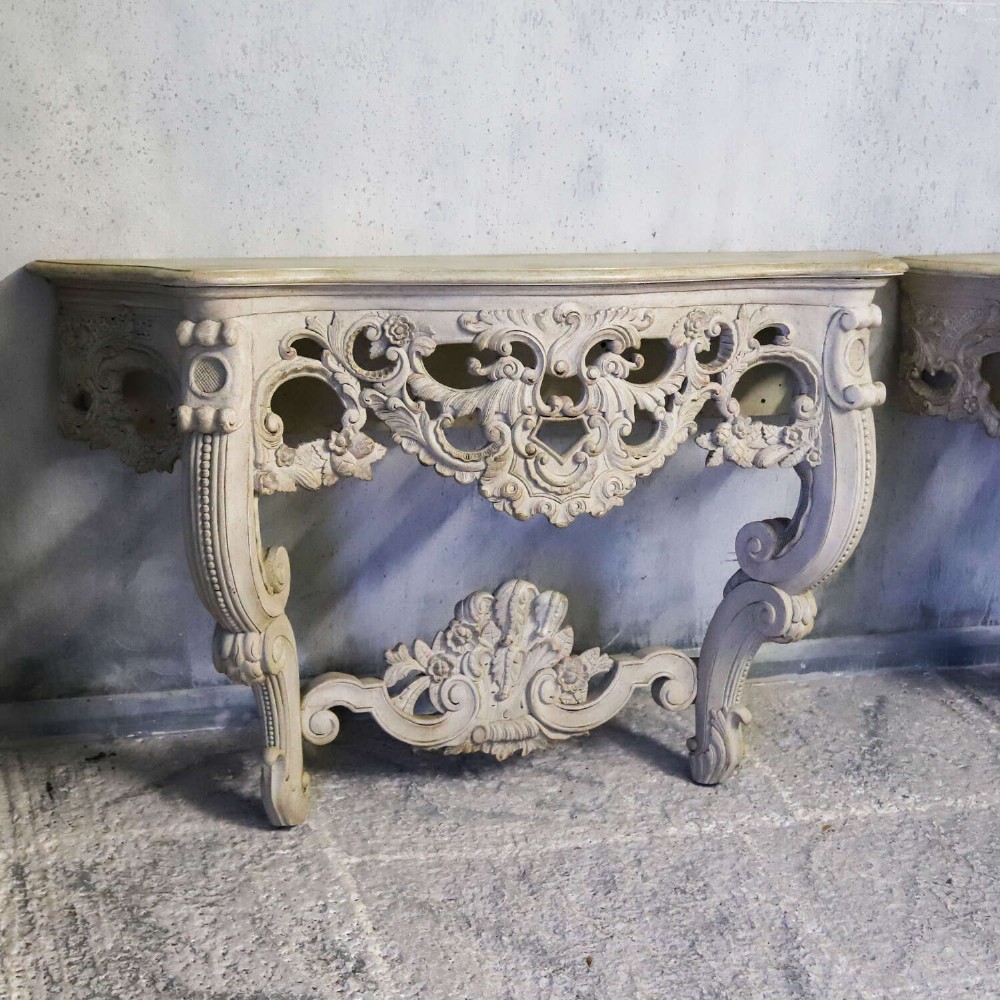 A pair of 1930s French wall console tables with intricate carved Rococo scrollwork in an antique white painted finish. View V
