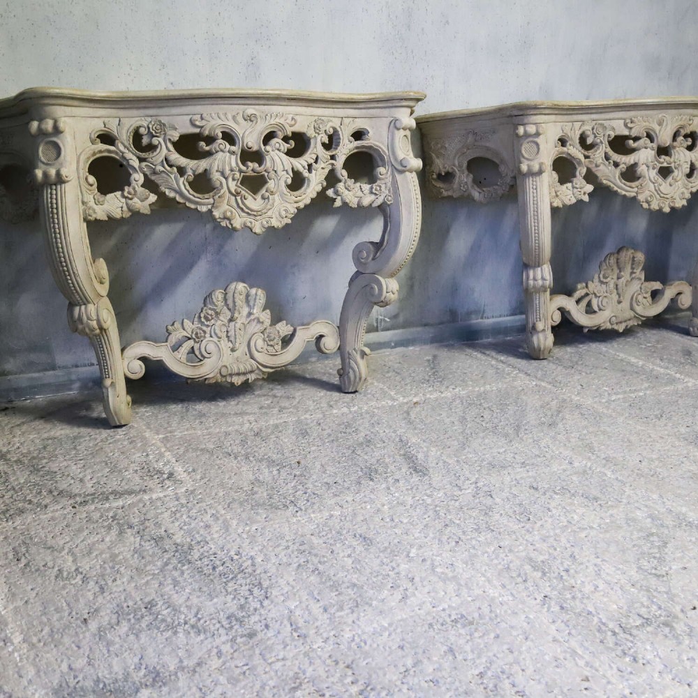 A pair of 1930s French wall console tables with intricate carved Rococo scrollwork in an antique white painted finish. View VI