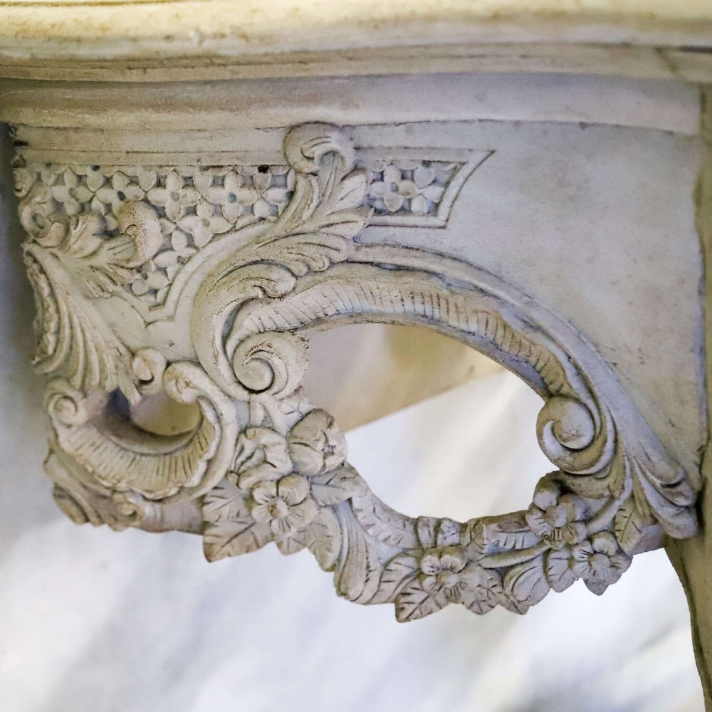 A pair of 1930s French wall console tables with intricate carved Rococo scrollwork in an antique white painted finish. View VIII