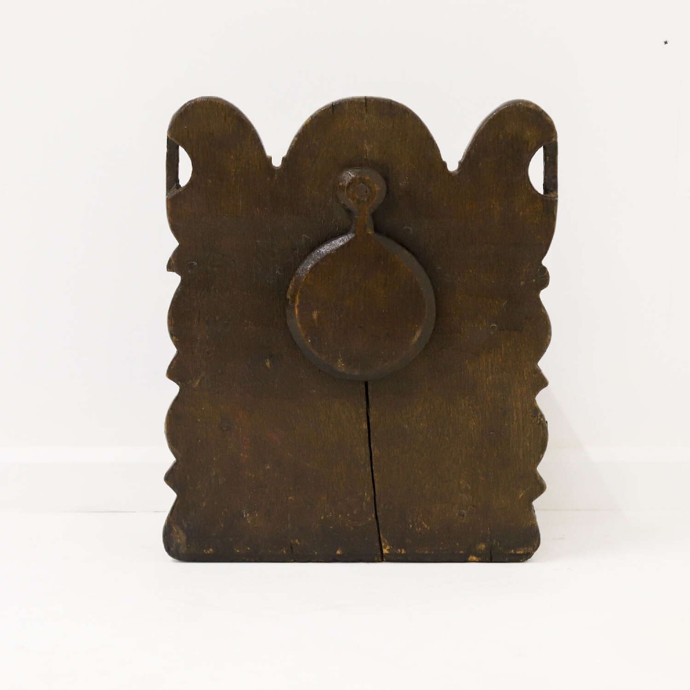 A dark brown 17th or 18th-century carved oak salt box featuring a shaped backboard with a circular hanging aperture and a sloping hinged lid. View II