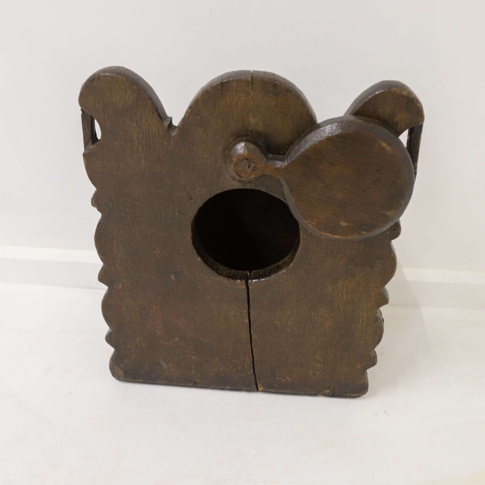 A dark brown 17th or 18th-century carved oak salt box featuring a shaped backboard with a circular hanging aperture and a sloping hinged lid. View VII