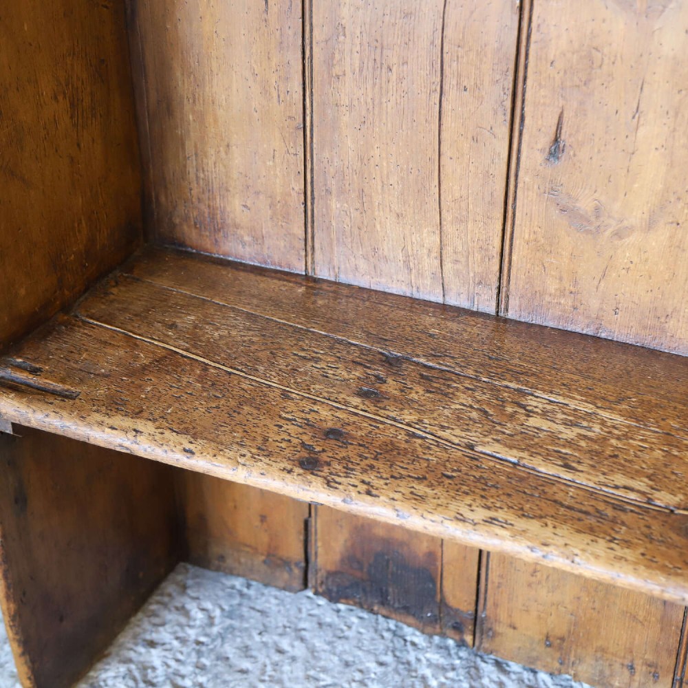 A 19th-century English country pine high-back settle bench with vertical timber panels and a warm honey brown finish. View II