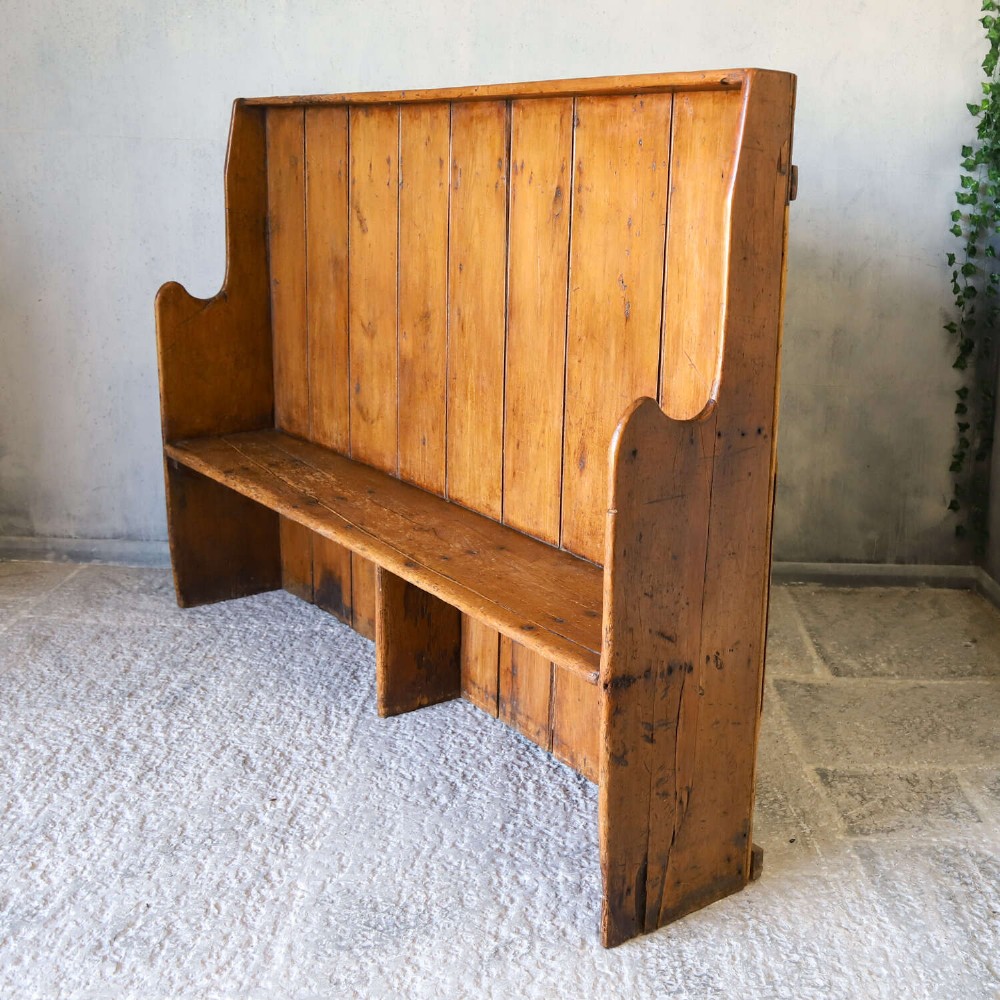 A 19th-century English country pine high-back settle bench with vertical timber panels and a warm honey brown finish. View XI