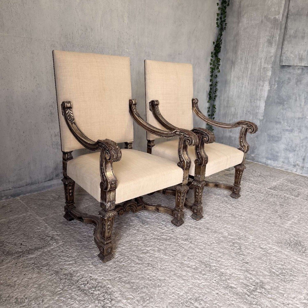 A pair of 19th-century Baroque-style throne armchairs featuring carved giltwood frames and neutral linen upholstery. View II