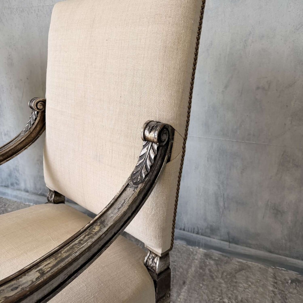A pair of 19th-century Baroque-style throne armchairs featuring carved giltwood frames and neutral linen upholstery. View IX
