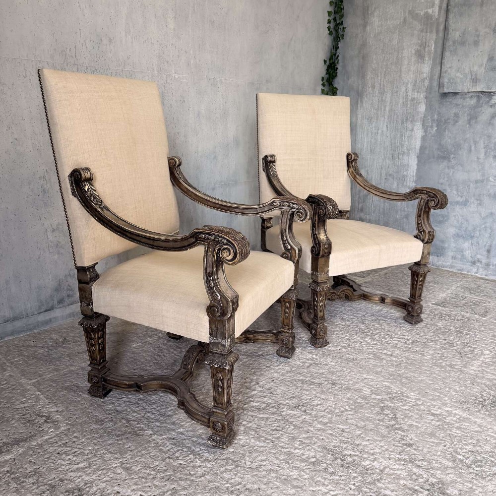 A pair of 19th-century Baroque-style throne armchairs featuring carved giltwood frames and neutral linen upholstery. View XII