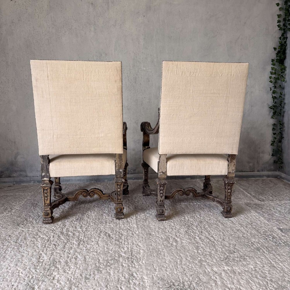 A pair of 19th-century Baroque-style throne armchairs featuring carved giltwood frames and neutral linen upholstery. View XIV