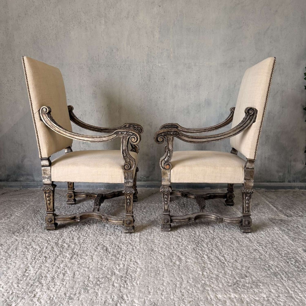 A pair of 19th-century Baroque-style throne armchairs featuring carved giltwood frames and neutral linen upholstery. View XV