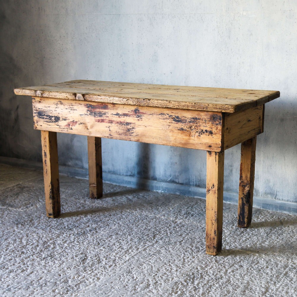 A rustic early twentieth-century Welsh pine work table featuring a thick timber plank top, deep apron, and simple straight square legs with a distressed finish. View IV