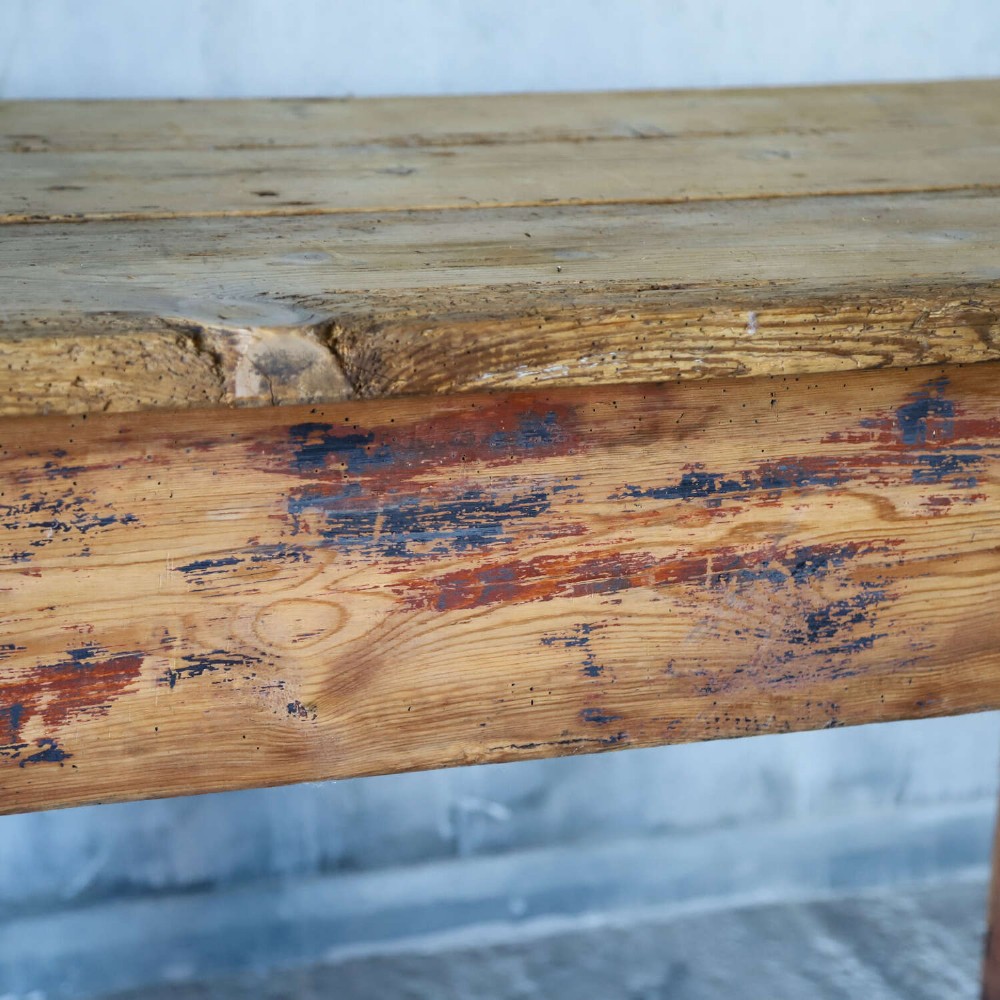 A rustic early twentieth-century Welsh pine work table featuring a thick timber plank top, deep apron, and simple straight square legs with a distressed finish. View VI