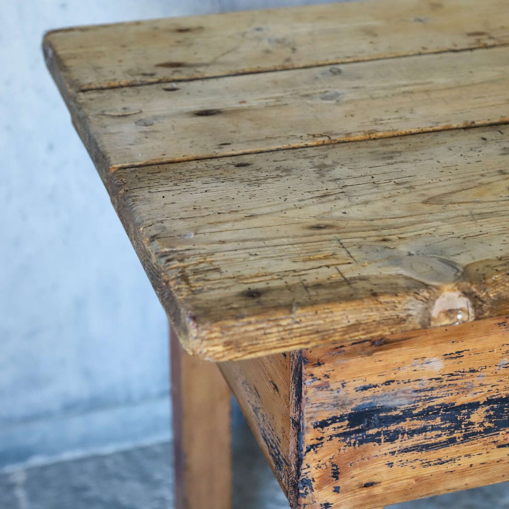 A rustic early twentieth-century Welsh pine work table featuring a thick timber plank top, deep apron, and simple straight square legs with a distressed finish. View VII