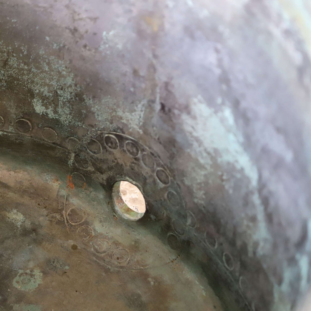 A large circular 19th-century copper tub featuring hand-riveted construction, side handles, and a blue-green verdigris patina. View VI