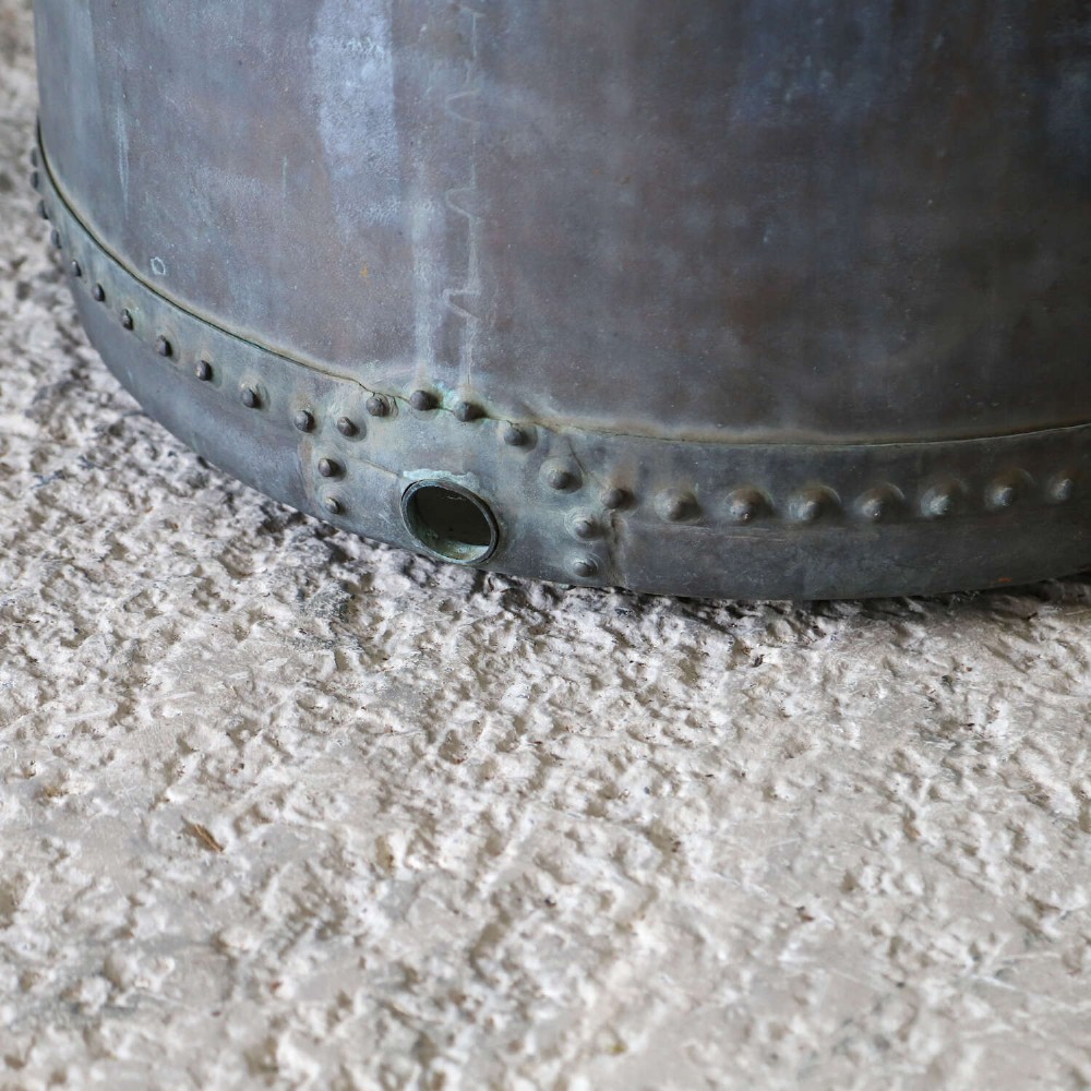 A large circular 19th-century copper tub featuring hand-riveted construction, side handles, and a blue-green verdigris patina. View VII