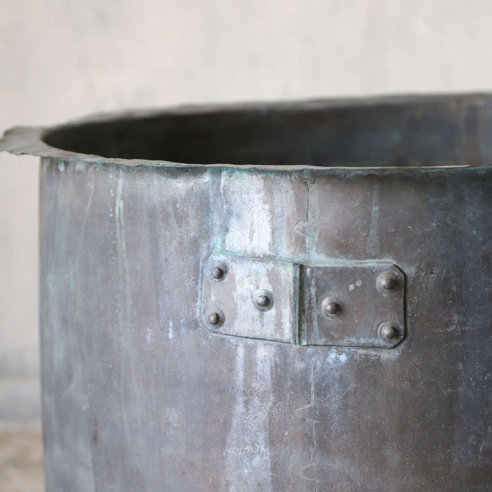 A large circular 19th-century copper tub featuring hand-riveted construction, side handles, and a blue-green verdigris patina. View VIII