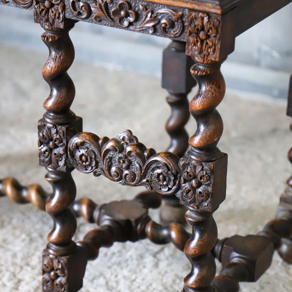 A dark oak Carolean Revival sideboard featuring two geometrically panelled drawers, intricate carving, and barley-twist legs connected by stretchers. View VI