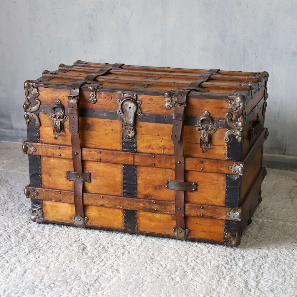 A 19th-century Victorian pine travelling trunk featuring wooden battens, iron corner brackets, central lock plate, and leather securing straps. View II