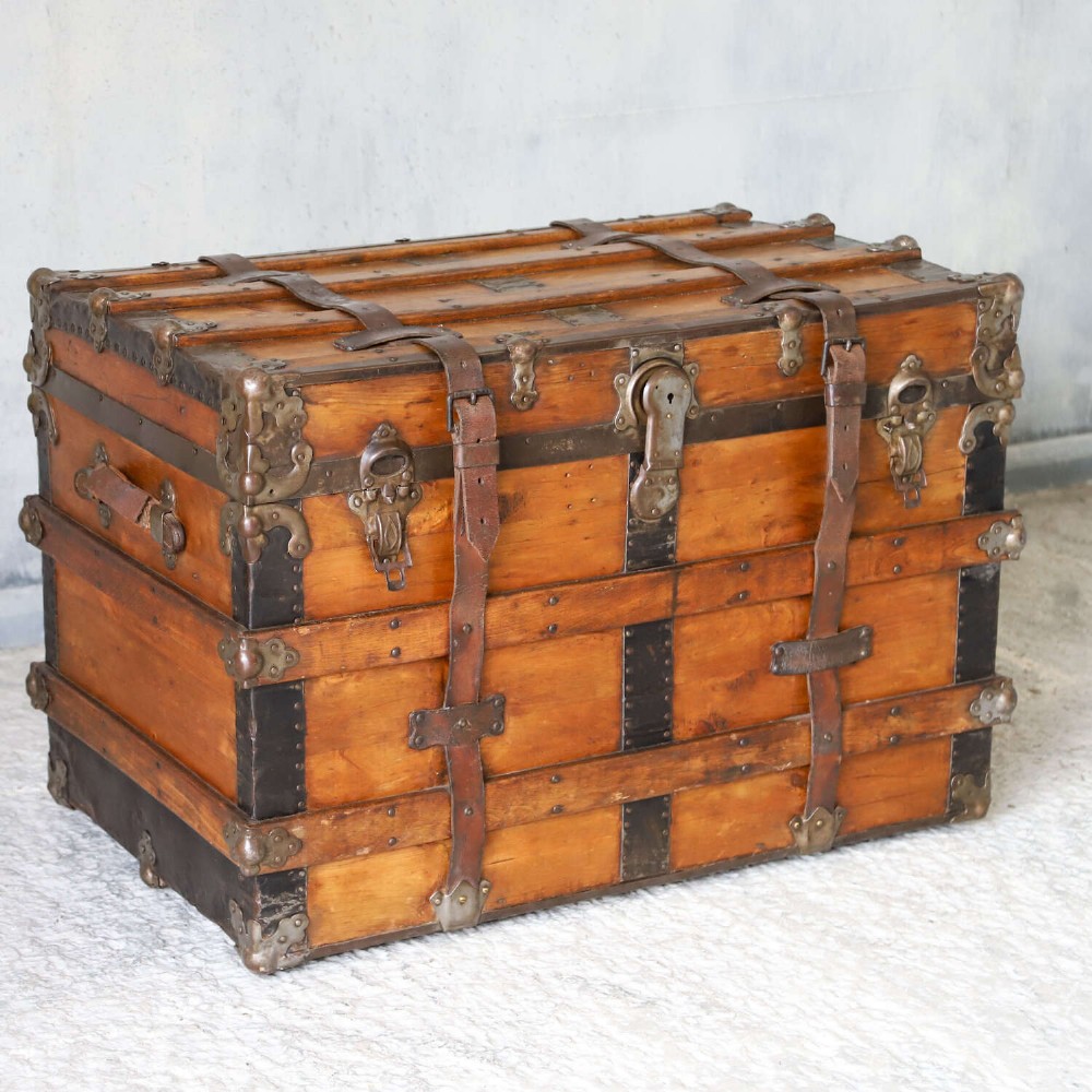 A 19th-century Victorian pine travelling trunk featuring wooden battens, iron corner brackets, central lock plate, and leather securing straps. View III