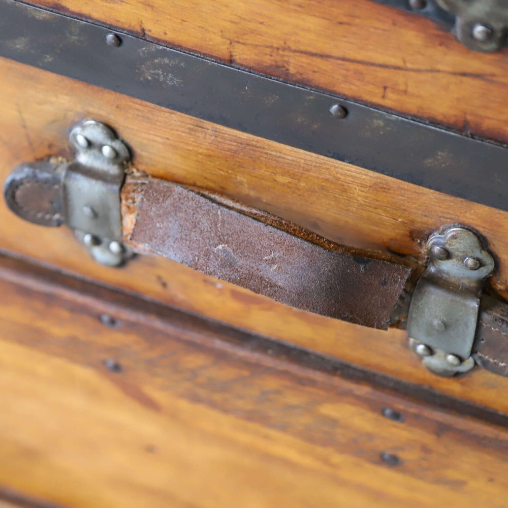 A 19th-century Victorian pine travelling trunk featuring wooden battens, iron corner brackets, central lock plate, and leather securing straps. View V