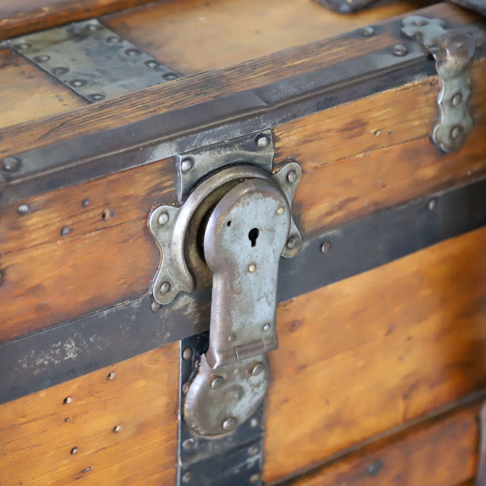A 19th-century Victorian pine travelling trunk featuring wooden battens, iron corner brackets, central lock plate, and leather securing straps. View VI