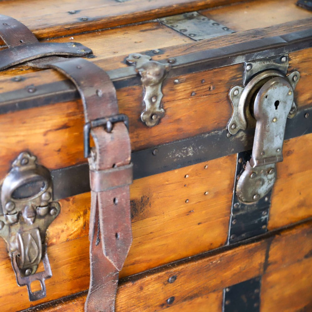 A 19th-century Victorian pine travelling trunk featuring wooden battens, iron corner brackets, central lock plate, and leather securing straps. View VII