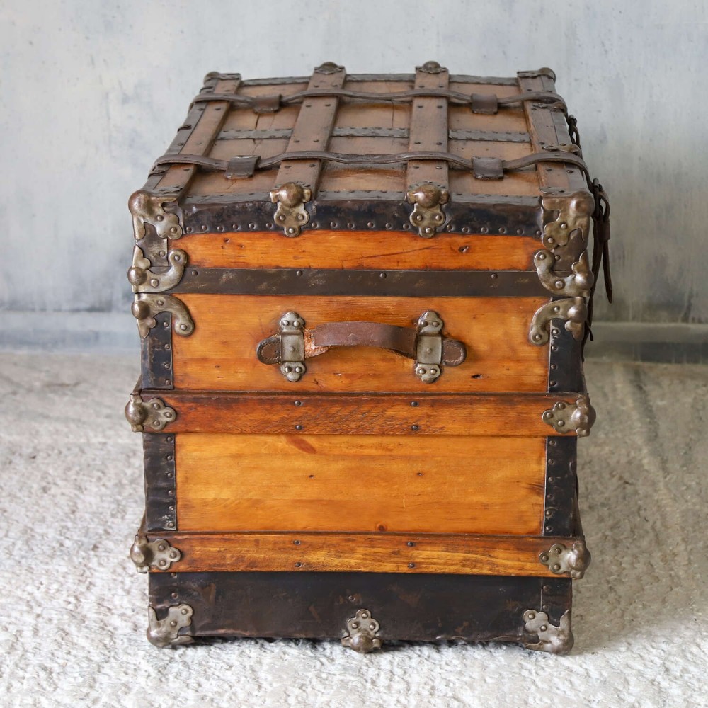 A 19th-century Victorian pine travelling trunk featuring wooden battens, iron corner brackets, central lock plate, and leather securing straps. View XI