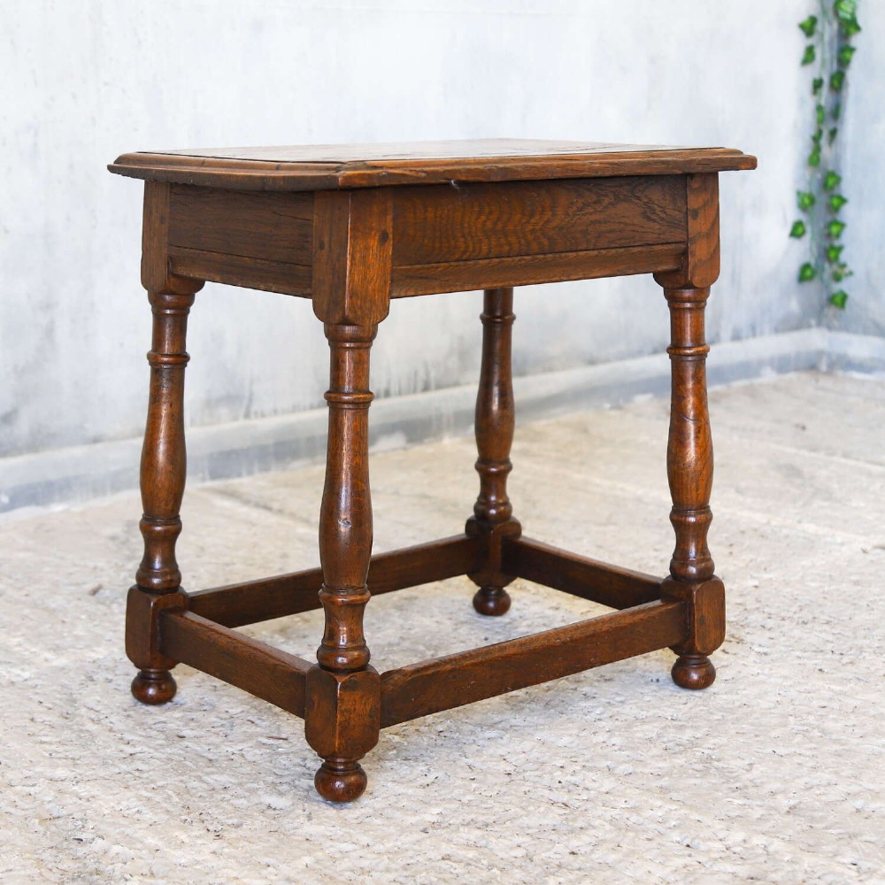 An 18th-century English Georgian oak joint stool featuring turned legs, perimeter stretchers, and a rectangular top with pegged joinery. View II