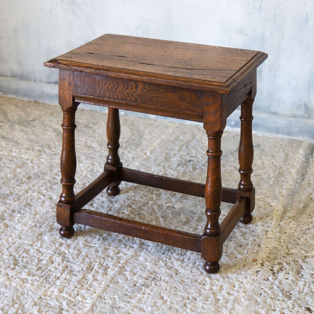 An 18th-century English Georgian oak joint stool featuring turned legs, perimeter stretchers, and a rectangular top with pegged joinery. View IV