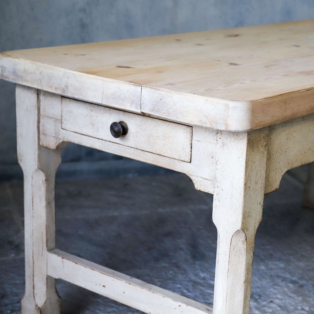A 19th-century English country house prep table featuring a thick natural timber top, an off-white painted wooden base, a side drawer, and low stretchers. View VIII