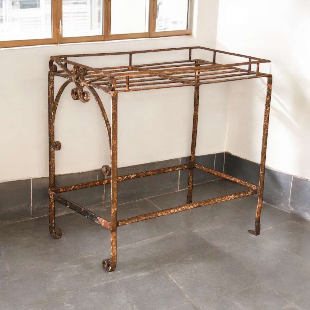 A rectangular wrought iron garden rack with a slatted top, decorative side scrollwork, and a weathered brown finish. View II