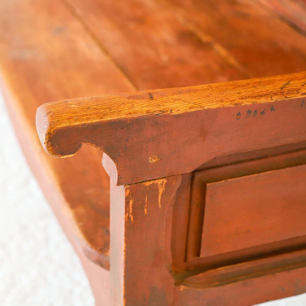 A late nineteenth-century Spanish wooden settle bench with a terracotta red painted frame, tall panelled backrest, shaped apron, and a natural timber seat. View V