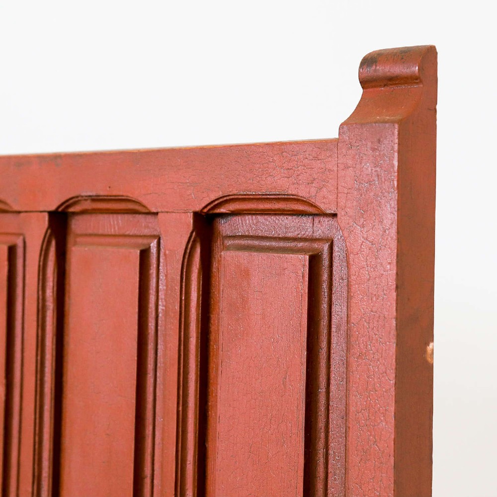 A late nineteenth-century Spanish wooden settle bench with a terracotta red painted frame, tall panelled backrest, shaped apron, and a natural timber seat. View VIII
