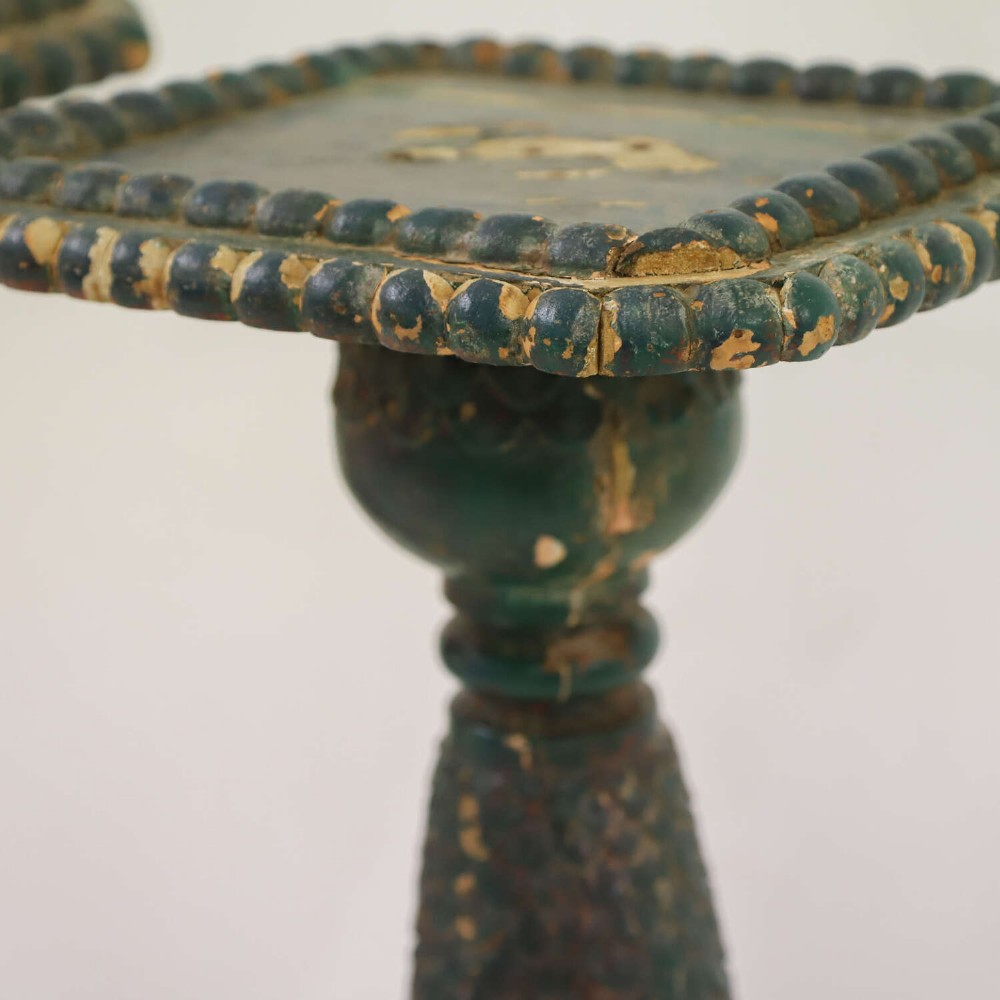 A pair of carved wooden torcheres featuring fish-scale carved baluster columns, square top platforms with beaded borders, scrolled feet, and distressed original green paint. View VI