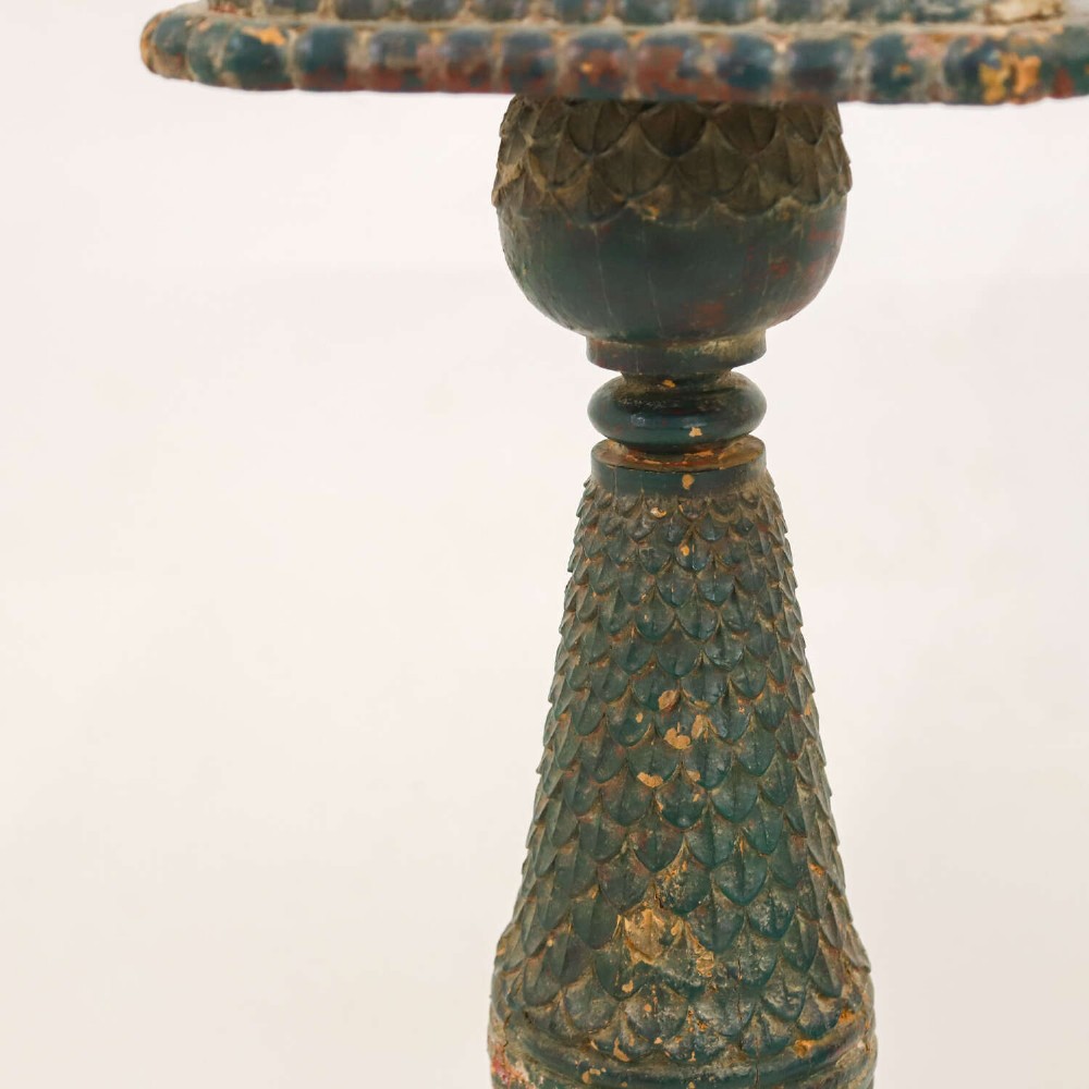 A pair of carved wooden torcheres featuring fish-scale carved baluster columns, square top platforms with beaded borders, scrolled feet, and distressed original green paint. View IX