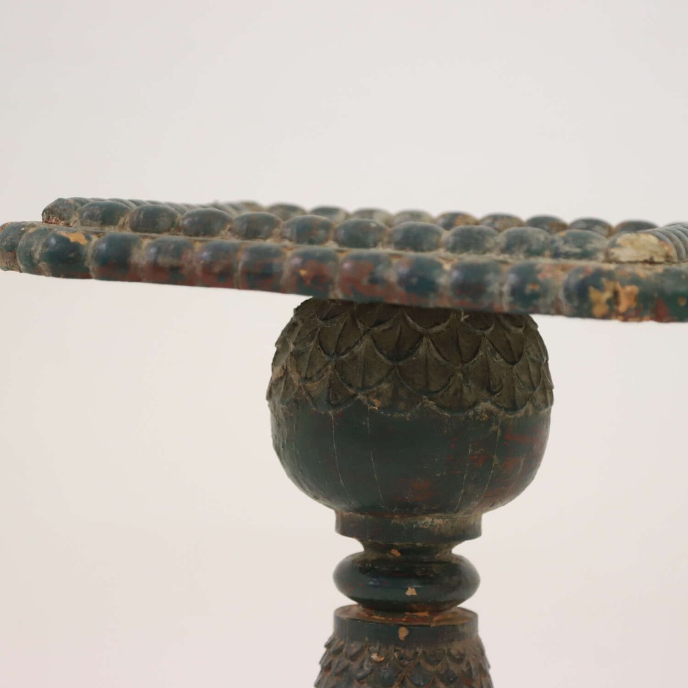 A pair of carved wooden torcheres featuring fish-scale carved baluster columns, square top platforms with beaded borders, scrolled feet, and distressed original green paint. View X