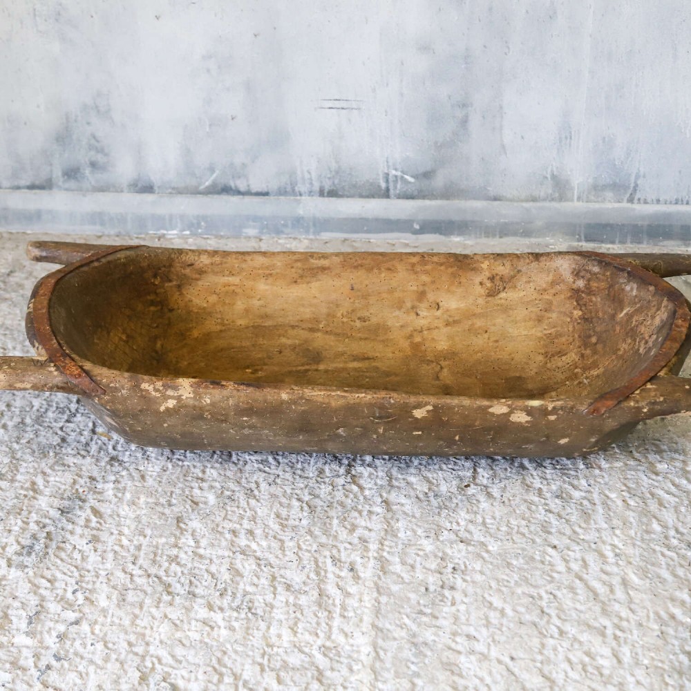 A hand-carved 19th-century French wooden dough trough with integrated handles and a weathered surface. View III