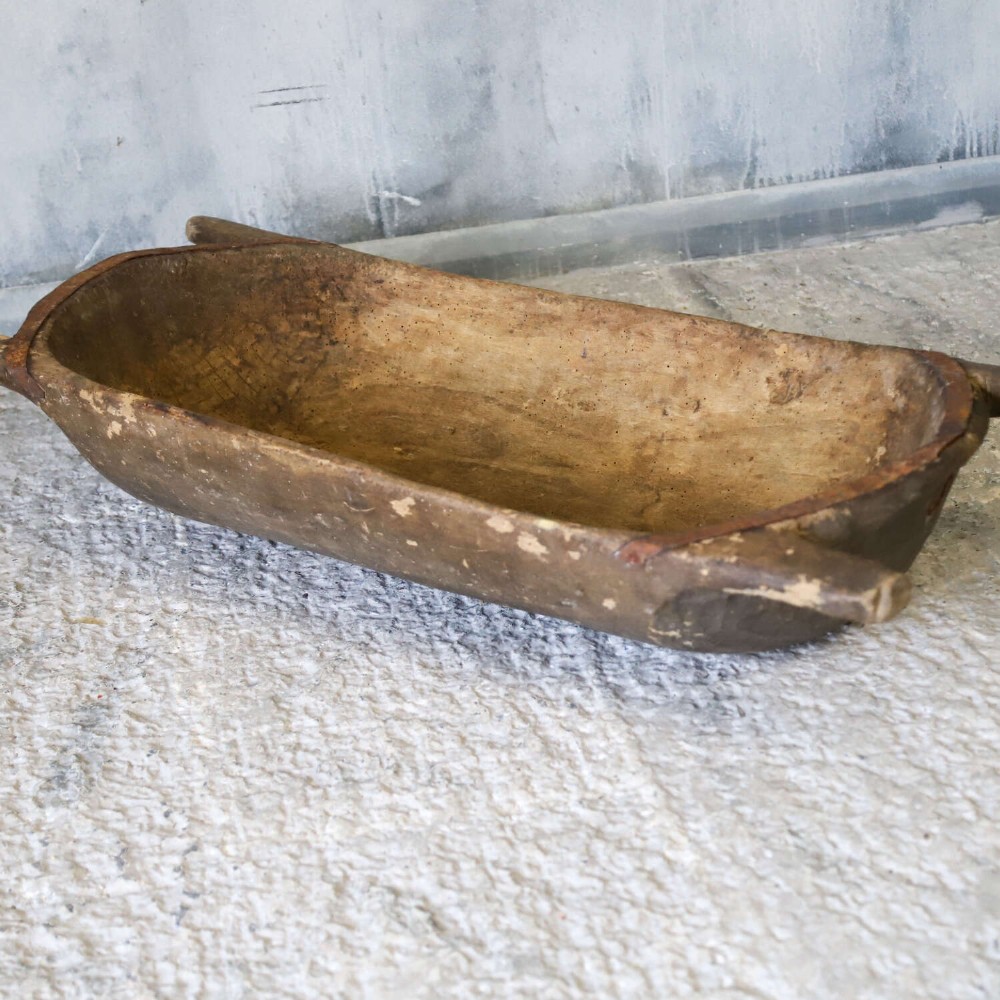 A hand-carved 19th-century French wooden dough trough with integrated handles and a weathered surface. View V