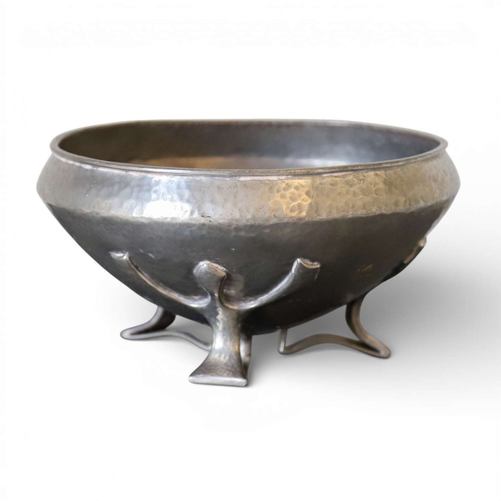 A hand-hammered grey pewter bowl featuring an inverted conical shape supported by stylised organic three-point legs.