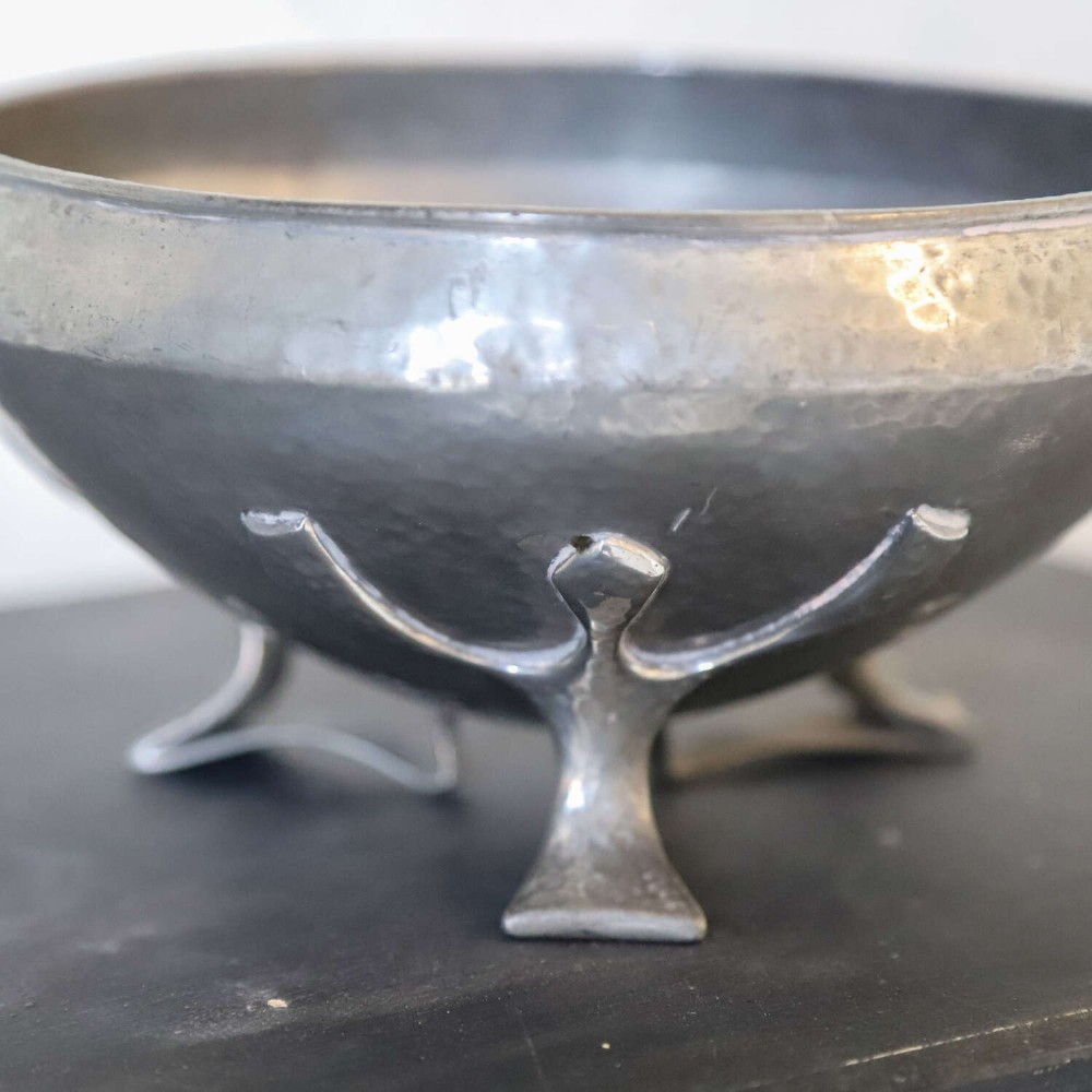 A hand-hammered grey pewter bowl featuring an inverted conical shape supported by stylised organic three-point legs. View III