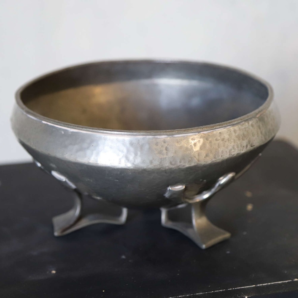 A hand-hammered grey pewter bowl featuring an inverted conical shape supported by stylised organic three-point legs. View IV