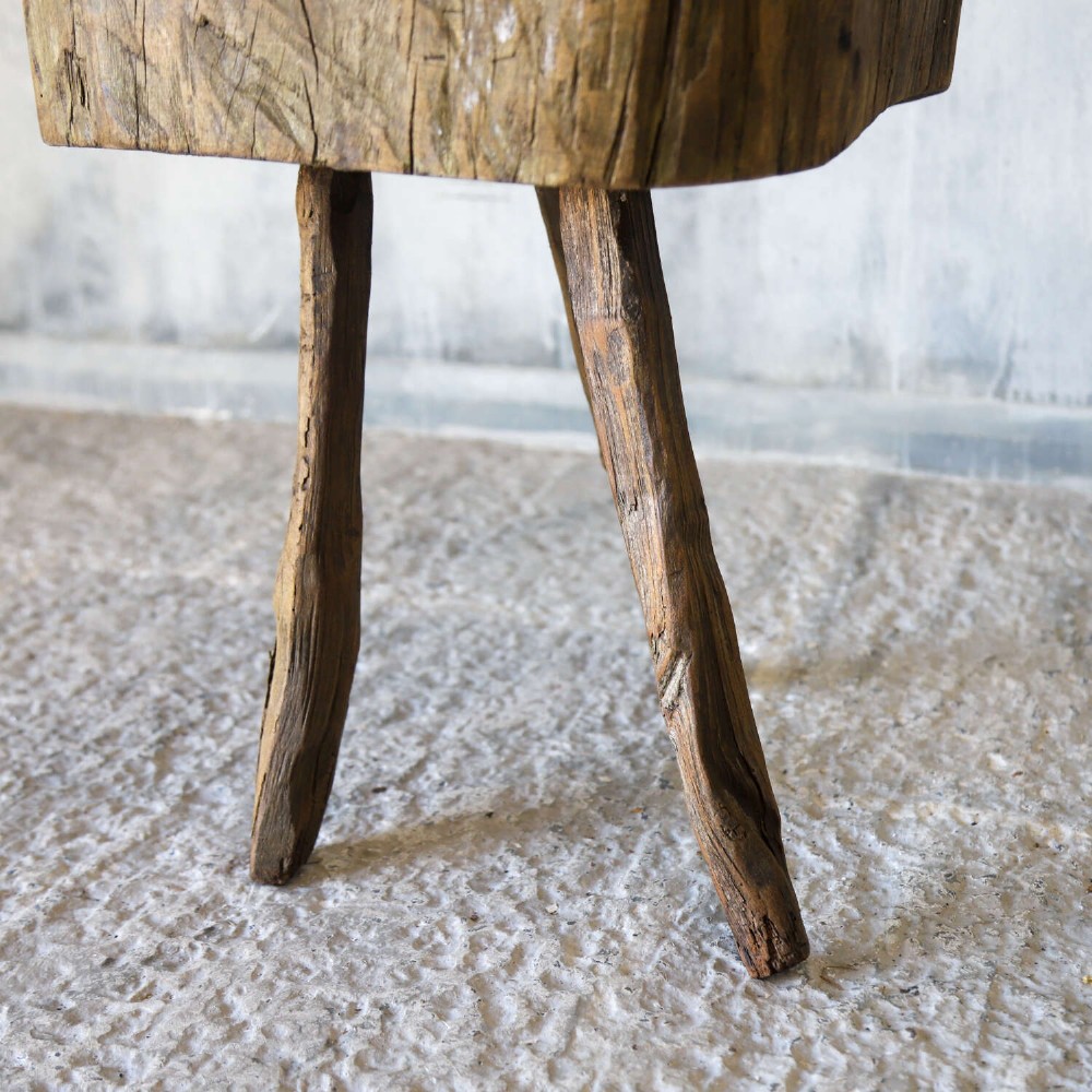 A 19th-century French elm chopping block featuring a heavy carved wooden top supported by three natural gnarled legs. View VII