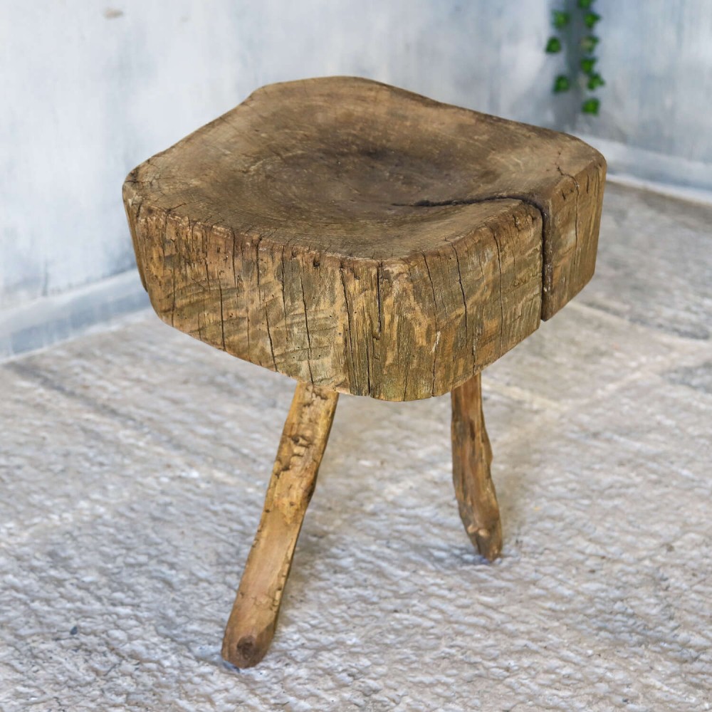 A 19th-century French elm chopping block featuring a heavy carved wooden top supported by three natural gnarled legs. View X